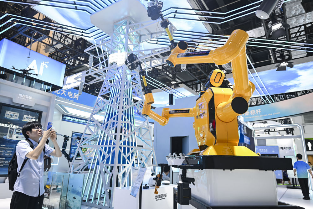 7月28日,在2025世界人工智能大会上,参观者在中国南方电网展区拍摄“悟空”带电作业机器人。新华社记者 陈浩明 摄.jpeg