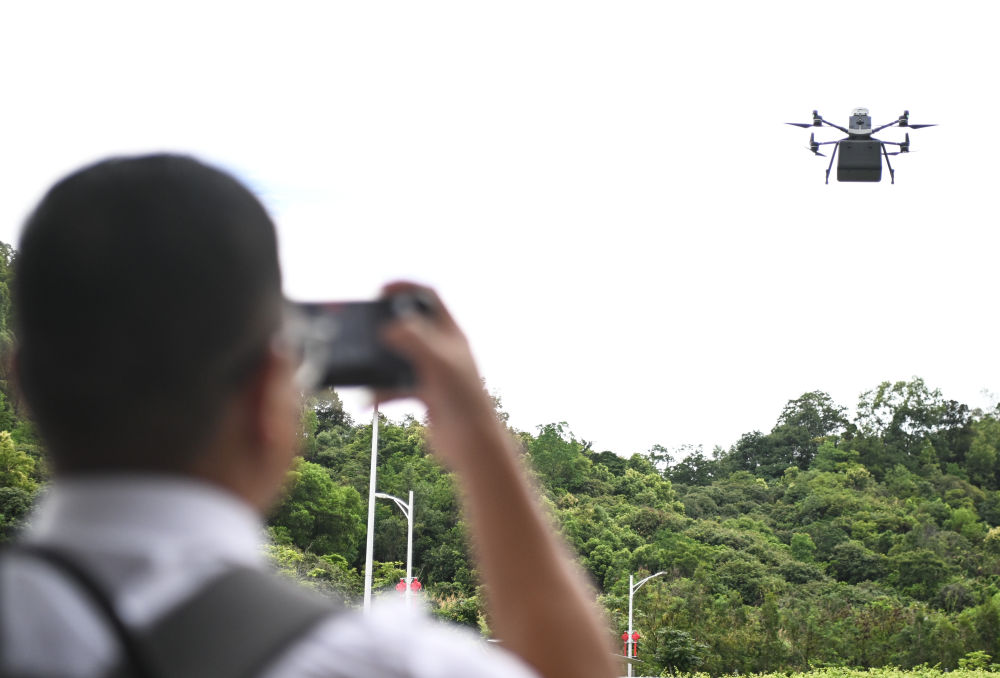 2025年6月26日,参观者在联合飞机集团深圳基地拍摄飞行中的物流无人机。新华社记者 邓华 摄.jpg